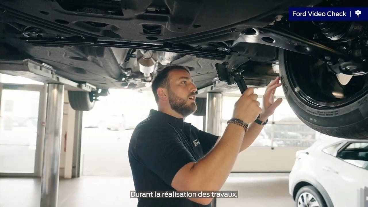 Ford Service Engineer checking under vehicle chassis