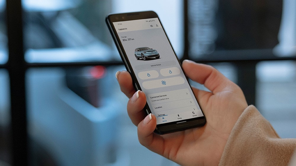 Gros plan d’une main tenant un smartphone et interagissant avec l’application FordPass. Gros plan d’une main tenant un smartphone et interagissant avec l’application FordPass.