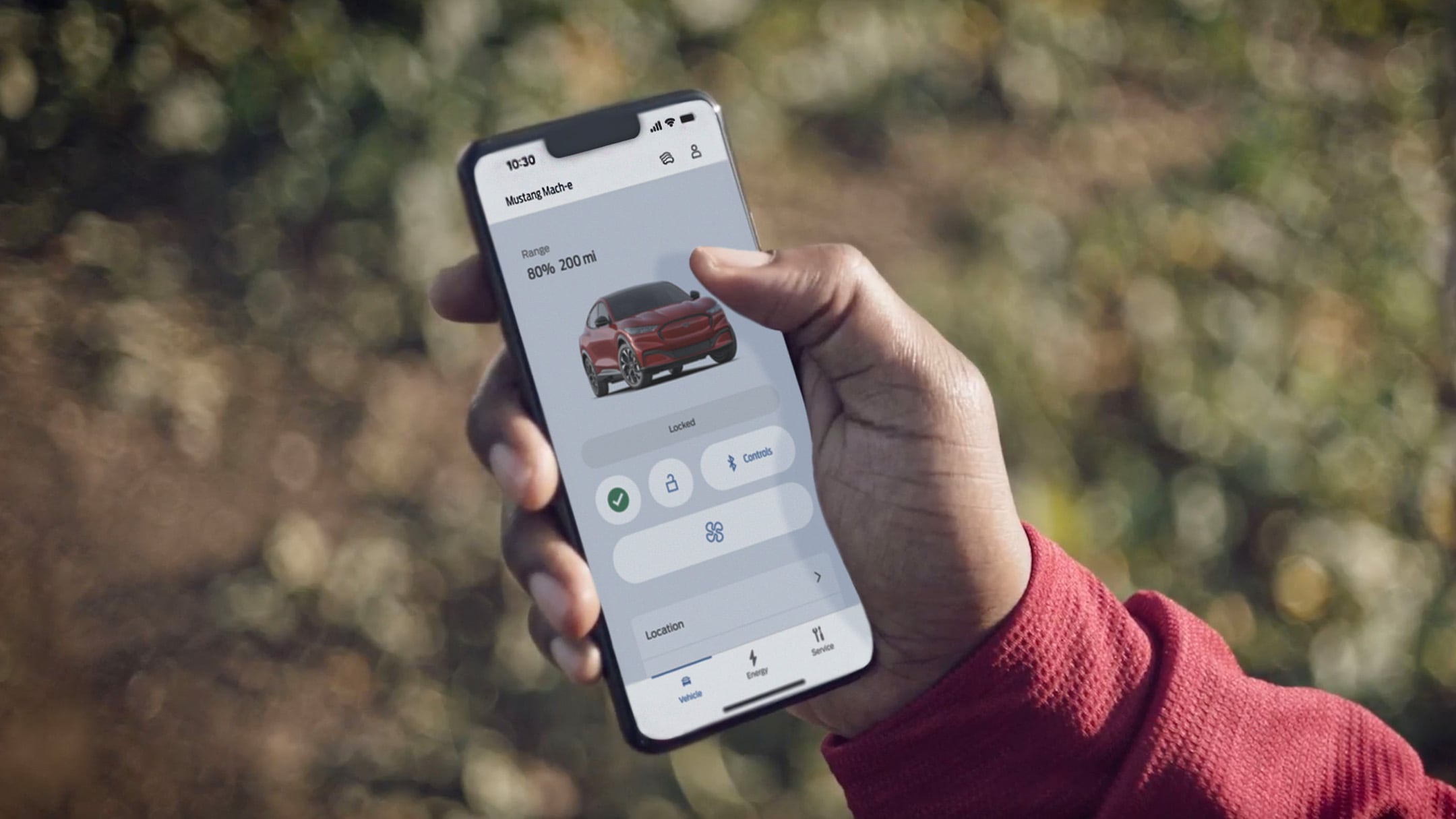 Man holding a phone using remote locking on the FordPass App